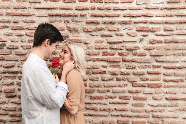 Photo gratuite vue latérale d'un couple heureux avec rose