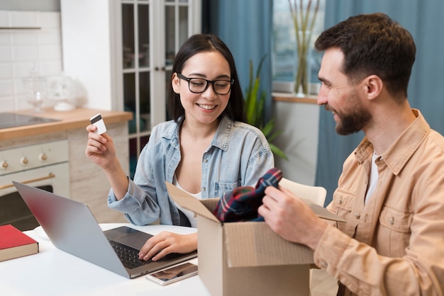 Vue latérale d'un couple profitant de la commande en ligne qu'ils ont reçue