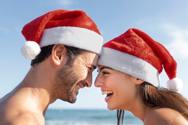 Vue latérale couple smiley au bord de la mer