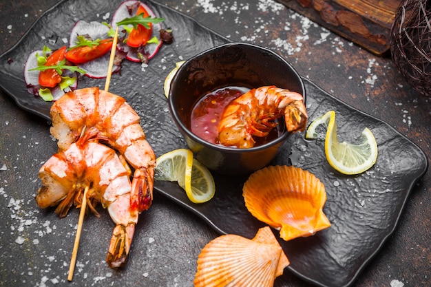 Vue latérale des crevettes frites dans une sauce épicée et des tranches de citron