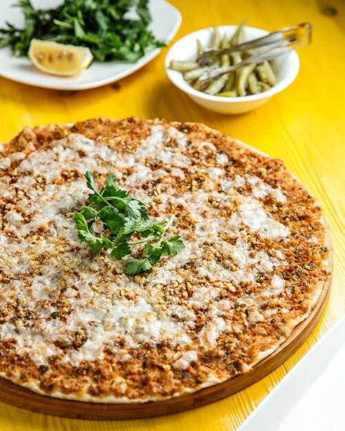 Vue latérale de la cuisine turque traditionnelle lahmacun avec fromage à la viande hachée et citron