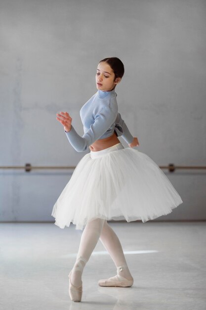 Vue latérale de la danse ballerine en jupe tutu et pointes