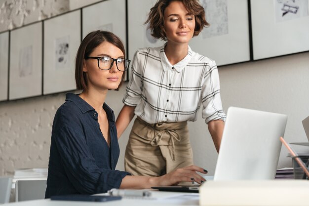 Vue latérale de deux femmes souriantes discutent de quelque chose