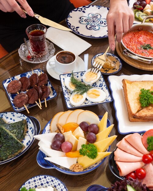 Vue latérale de diverses assiettes de nourriture pour le petit déjeuner comme des œufs frits toasts le thé avec douceur