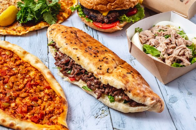 Vue latérale doner viande pain blanc avec de la laitue de viande grillée et tomate sur la table