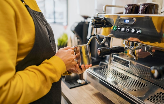 Vue latérale du barista à l'aide de la machine