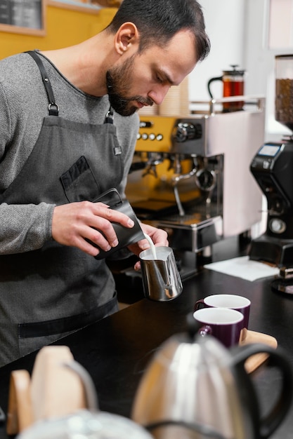 Vue latérale du barista masculin préparer le café