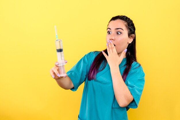 La vue latérale du bon médecin avec une seringue fera une injection