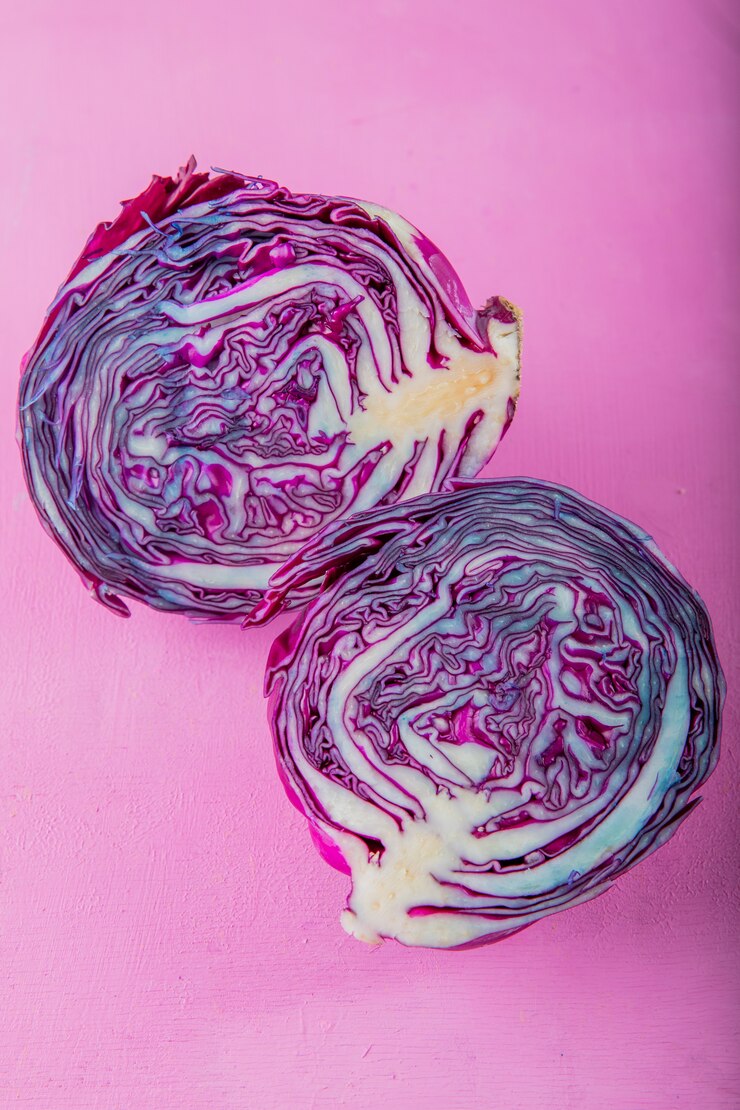 Photo gratuit vue latérale du chou violet à moitié coupé sur fond violet avec copie espace