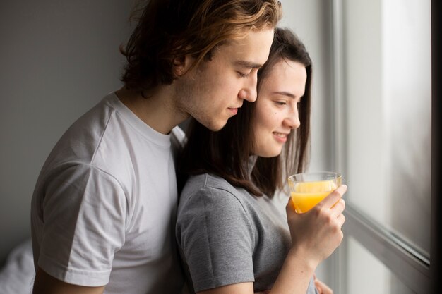 Vue latérale du couple d'amoureux près de la fenêtre