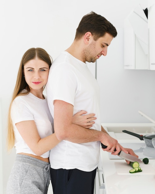 Vue latérale du couple dans la cuisine