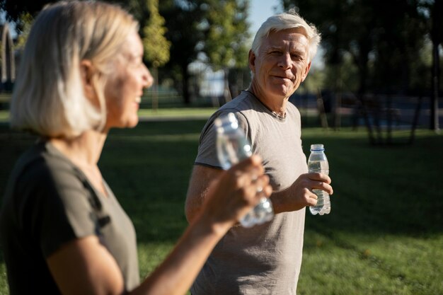 Vue latérale du couple eau potable à l'extérieur