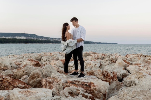 Vue latérale du couple romantique embrassé par l'océan