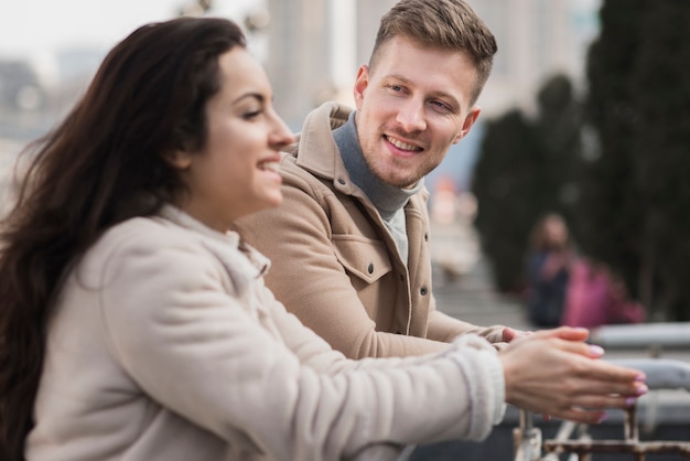 Vue latérale du couple smiley à l'extérieur