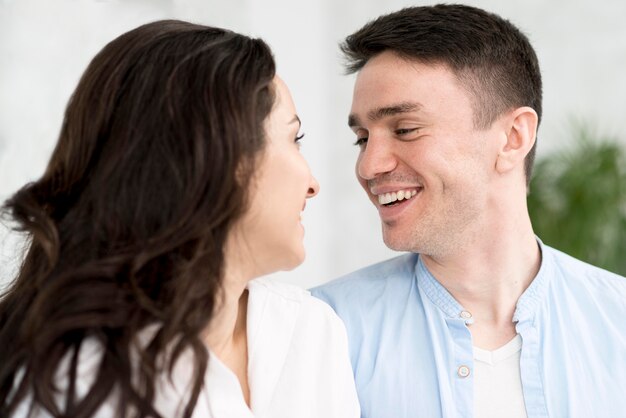 Vue latérale du couple souriant à la maison