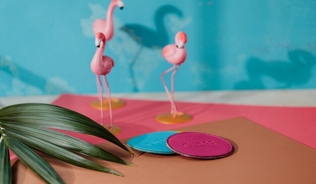 Vue latérale du dessous de verre en cuir bleu et rose sur le mur de petites figures de flamant rose