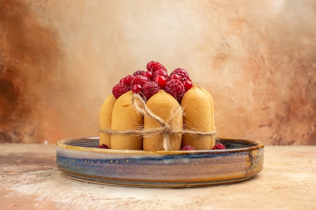 Photo gratuite vue latérale du gâteau cadeau fraîchement sorti du four avec des fruits sur un plateau bleu sur table de couleurs mixtes