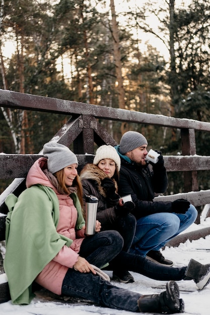 Vue latérale du groupe d'amis prenant un verre à l'extérieur en hiver