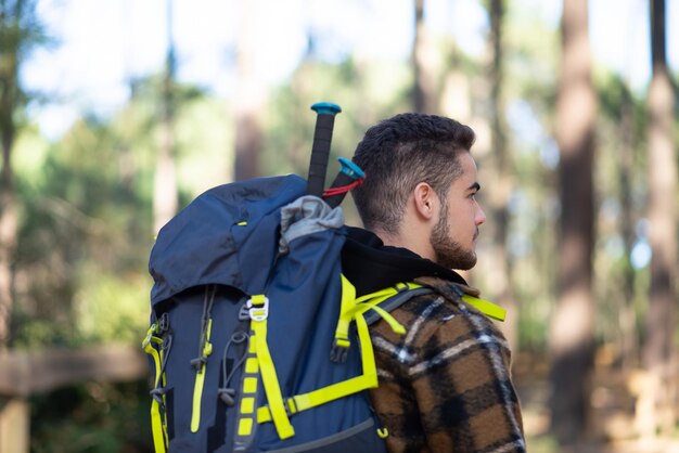 Photo gratuite vue latérale du jeune randonneur masculin. homme caucasien avec barbe et gros sac à dos. passe-temps, concept nature