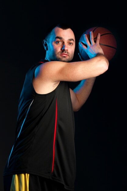 Vue latérale du joueur de basket-ball se préparant à lancer la balle