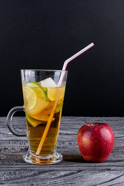 Vue latérale du jus de pomme sur une table en bois gris vertical