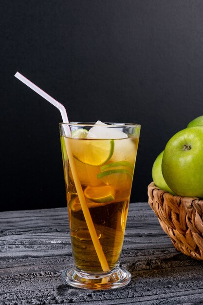 Vue latérale du jus de pomme sur une table en bois gris