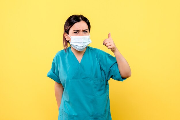 Vue latérale du médecin en masque parle de covid