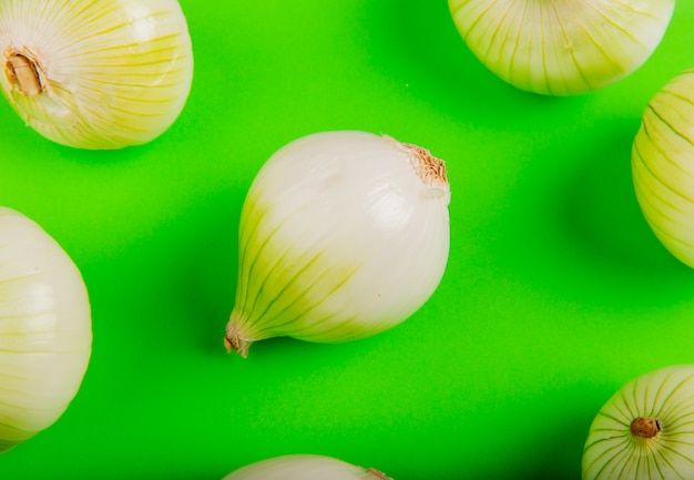 Photo gratuite vue latérale du motif d'oignons sur la table verte