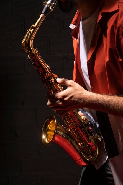 Vue latérale du musicien masculin jouant du saxophone