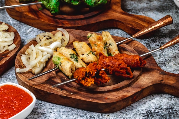 Photo gratuite vue latérale du pain à l'ail avec de la viande hachée verte et des oignons grillés sur une planche