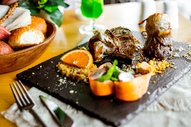 Vue latérale du poisson frit avec sauce et une tranche d'orange aux légumes