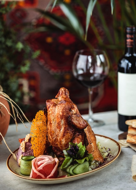 Vue latérale du poulet rôti avec des légumes frais sur une plaque blanche