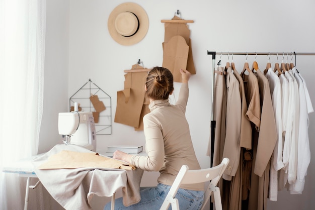 Vue latérale du tailleur féminin travaillant dans le studio