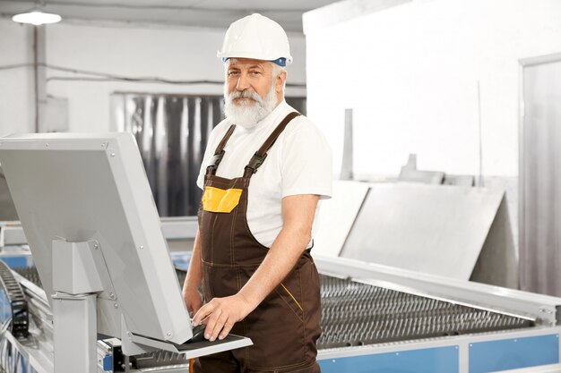 Vue latérale du travailleur professionnel de l'usine de métal