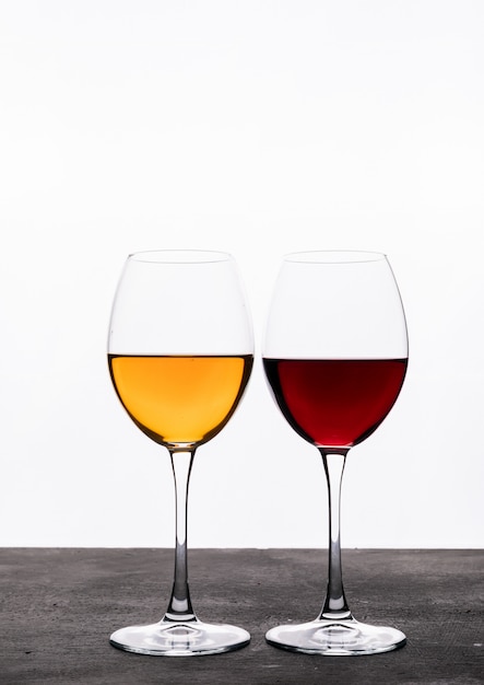 Vue latérale du vin dans des verres sur blanc vertical