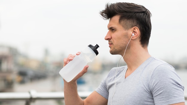 Photo gratuite vue latérale de l'eau potable pour hommes adultes