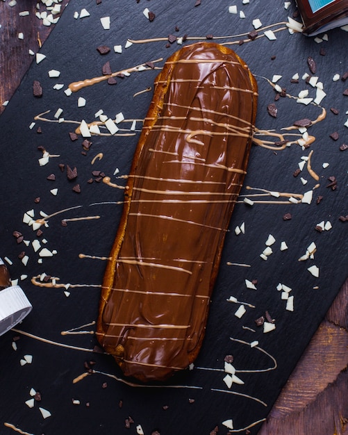 Photo gratuite vue latérale de l'éclair unique avec du chocolat sur une surface en bois