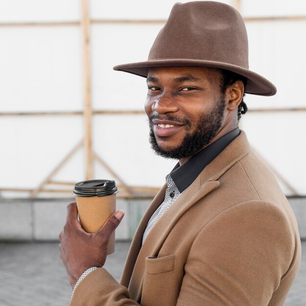 Vue latérale élégant homme afro-américain tenant une tasse de café