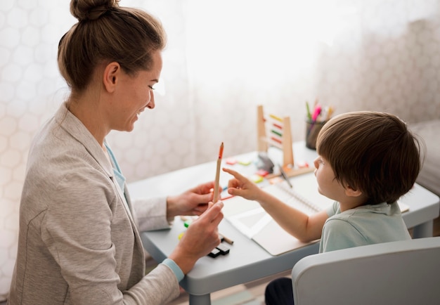 Vue latérale de l'enfant et du tuteur à la maison