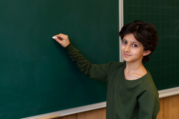 Vue latérale enfant écrivant à bord