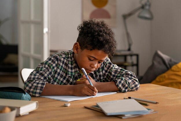 Vue latérale enfant faisant ses devoirs à la maison