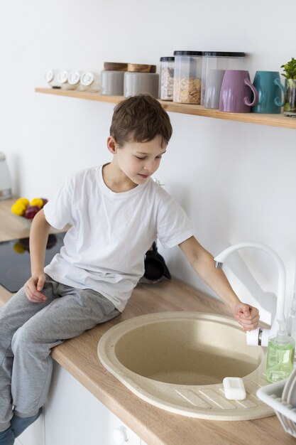 Vue latérale d'un enfant se lavant les mains