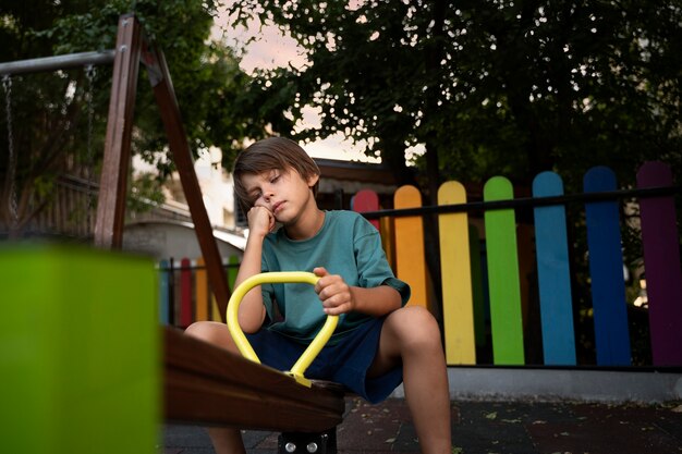 Vue latérale enfant triste dans le parc