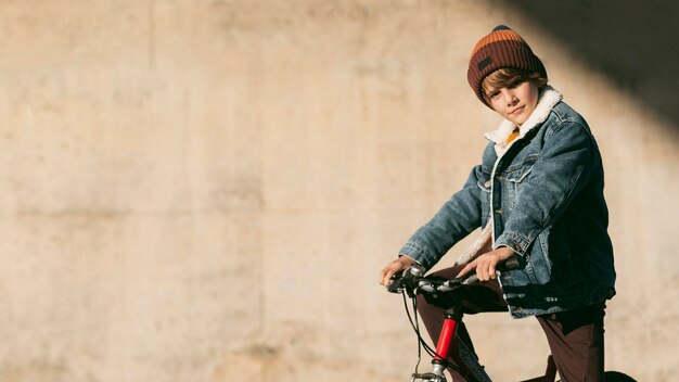 Vue latérale de l'enfant à vélo à l'extérieur avec espace copie