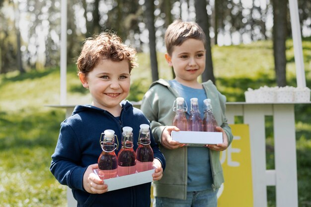 Vue latérale des enfants avec des bouteilles de limonade