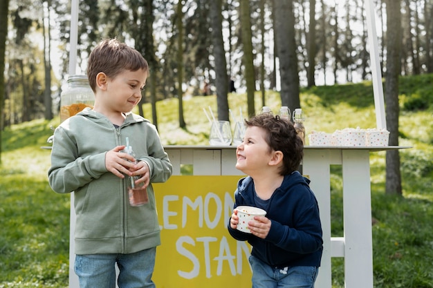 Vue latérale des enfants avec de la limonade et du pop-corn