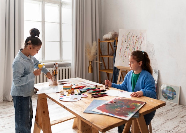 Photo gratuite vue latérale des enfants peignant à l'école