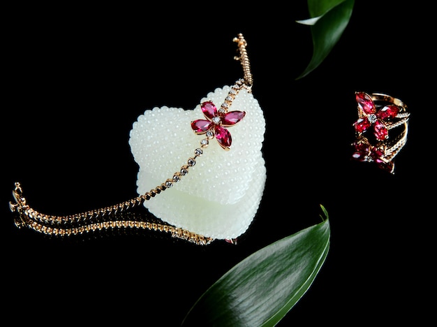 Vue latérale de l'ensemble de bijoux de bracelet en or et de couenne avec diamants et rubis en forme de papillon