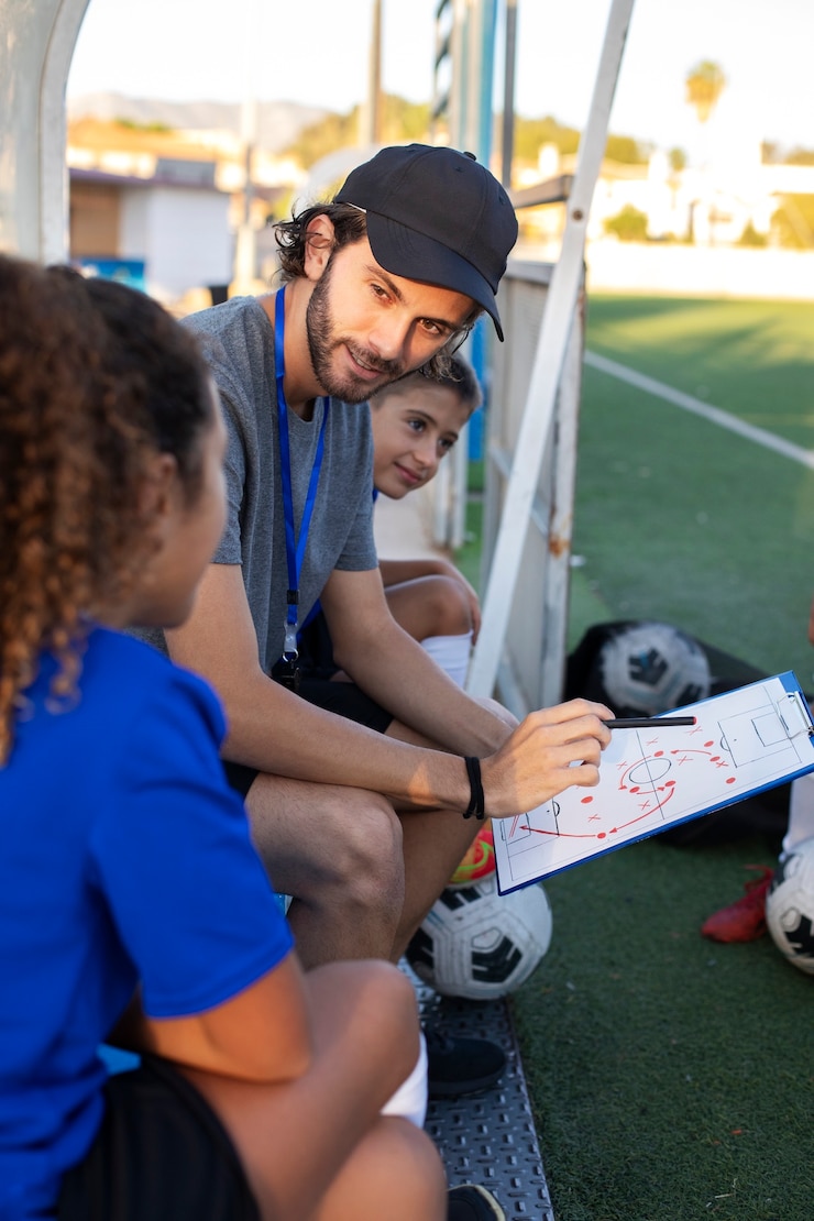 Photo gratuit vue latérale entraîneur de football enseignant aux enfants