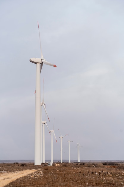 Photo gratuite vue latérale des éoliennes produisant de l'électricité sur le terrain